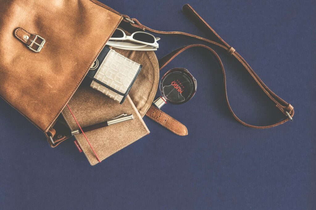 brown leather crossbody bag with white framed sunglasses